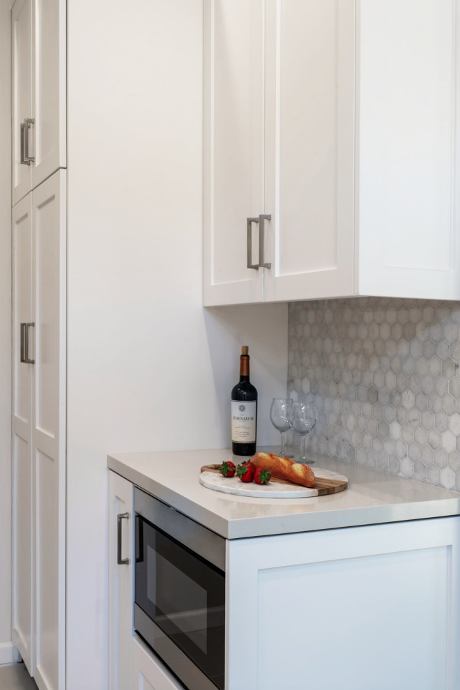 Inspiration for a small transitional galley light wood floor and beige floor enclosed kitchen remodel in San Francisco with an undermount sink, shaker cabinets, white cabinets, quartz countertops, gray backsplash, mosaic tile backsplash, stainless steel appliances and yellow countertops