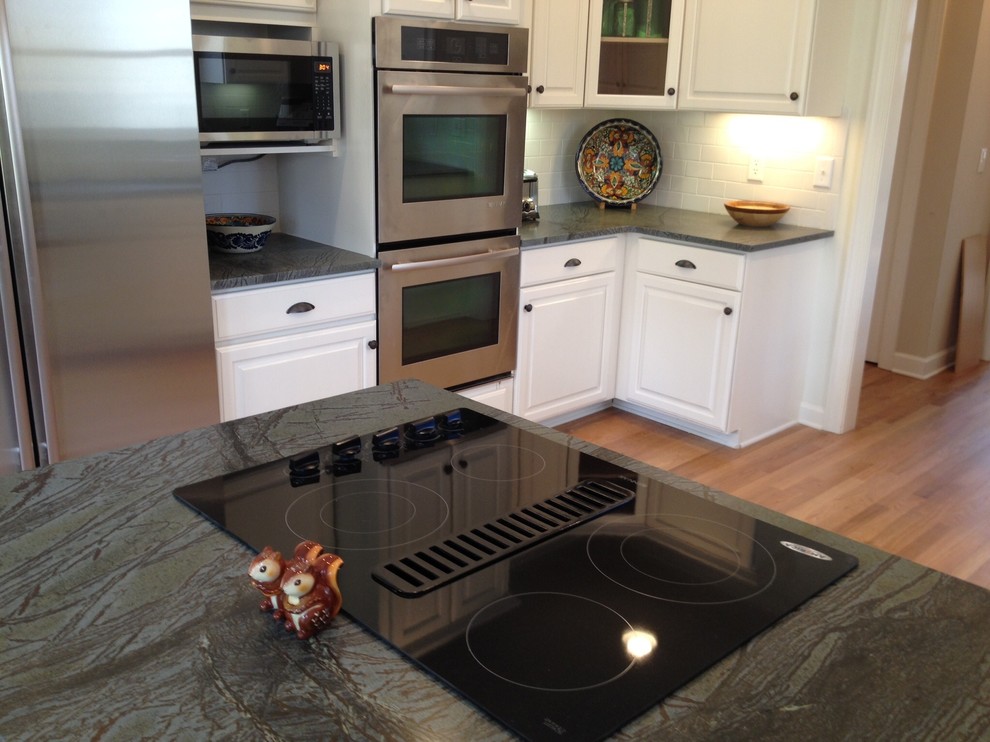 Inspiration for a light wood floor kitchen remodel with soapstone countertops, white backsplash and ceramic backsplash