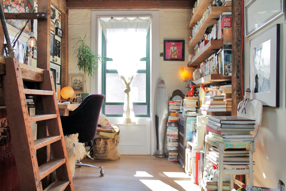 This is an example of a country home office in New York with white walls, light hardwood floors, no fireplace and a built-in desk.