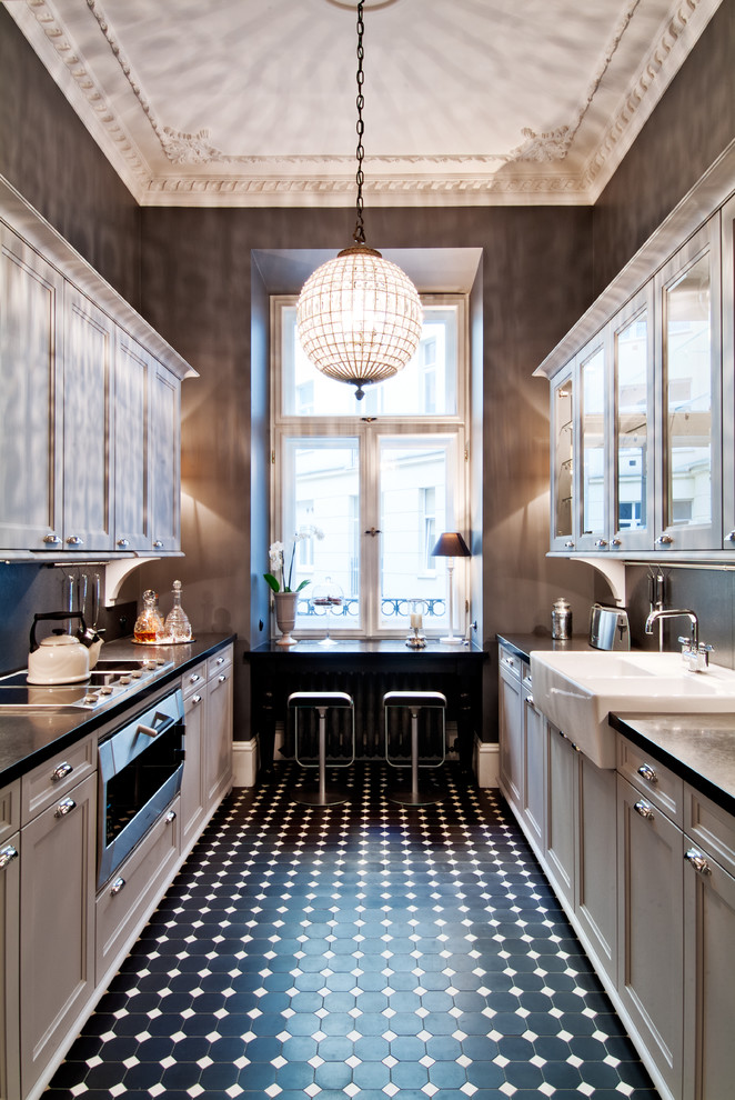 Design ideas for a traditional galley separate kitchen in New York with a farmhouse sink, glass-front cabinets, stainless steel appliances, granite benchtops and black splashback.