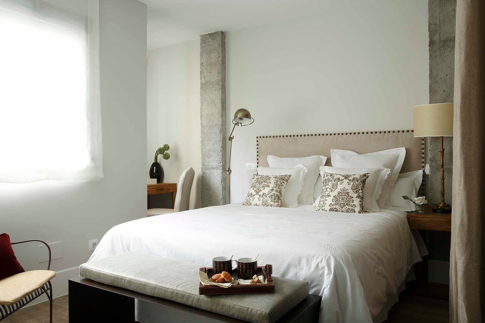 This is an example of a mid-sized transitional master bedroom in Madrid with no fireplace and white walls.