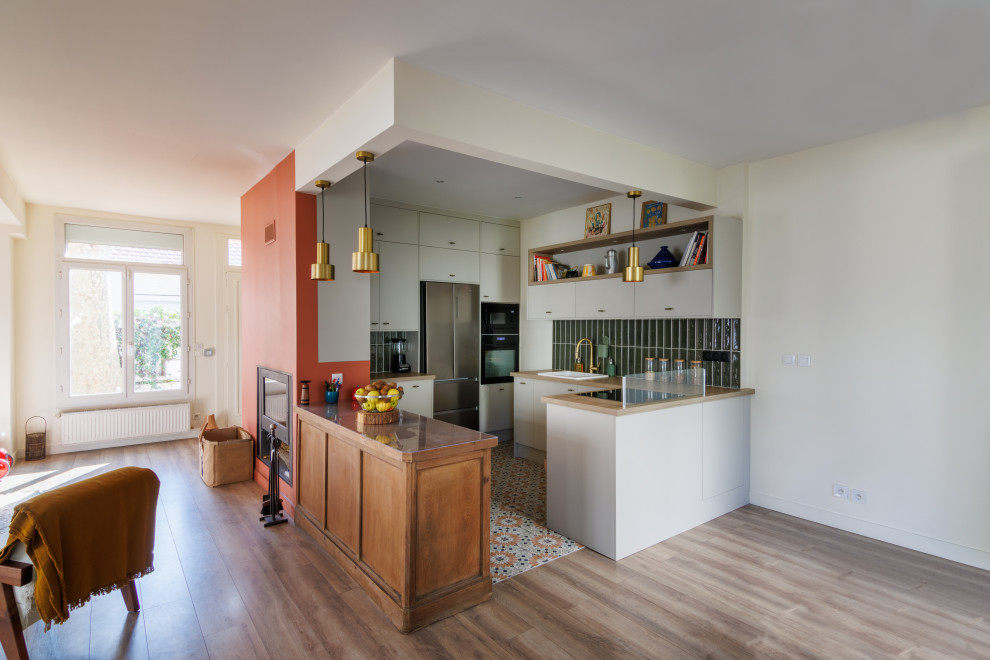 Exemple d'une cuisine rétro avec un plan de travail en bois, une crédence verte, carreaux de ciment au sol, 2 îlots et un plan de travail beige.