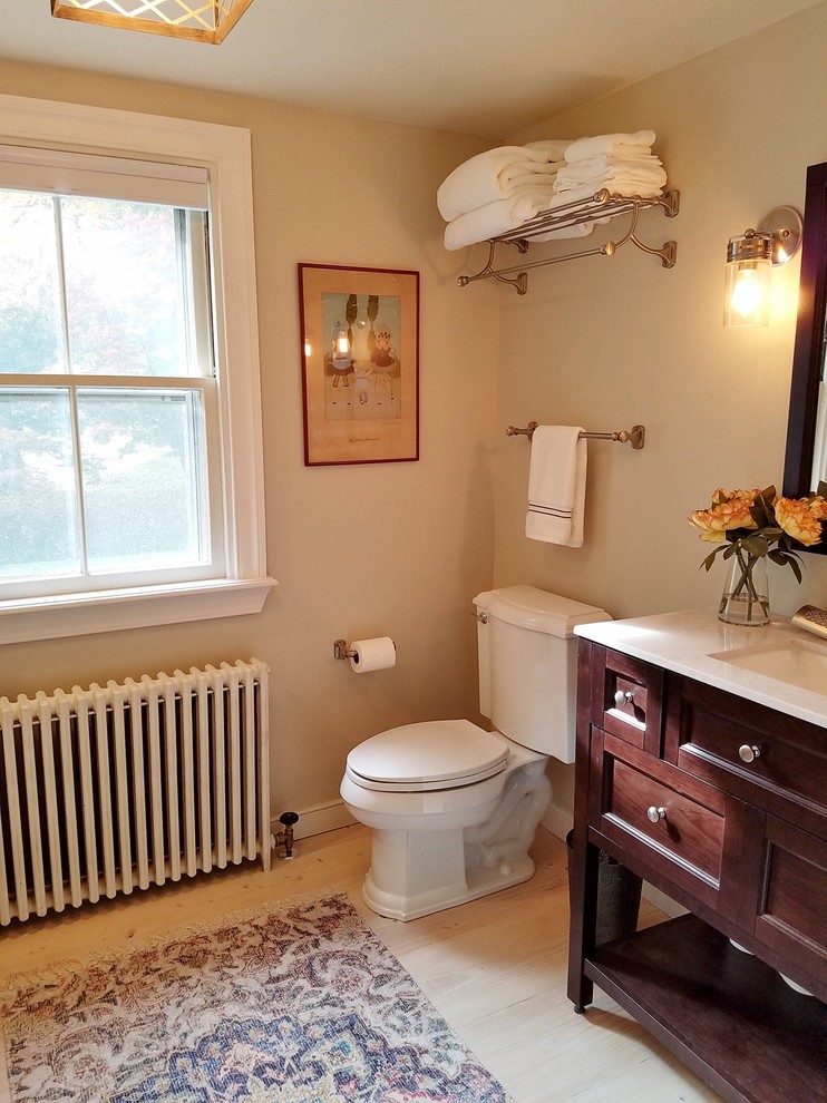 This is an example of a mid-sized country 3/4 bathroom in Philadelphia with furniture-like cabinets, dark wood cabinets, an open shower, white tile, subway tile, grey walls, light hardwood floors, an undermount sink, marble benchtops, white floor and white benchtops.