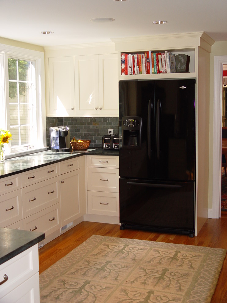 Kitchen - transitional kitchen idea in Boston with an undermount sink, recessed-panel cabinets, white cabinets, granite countertops, black appliances and an island