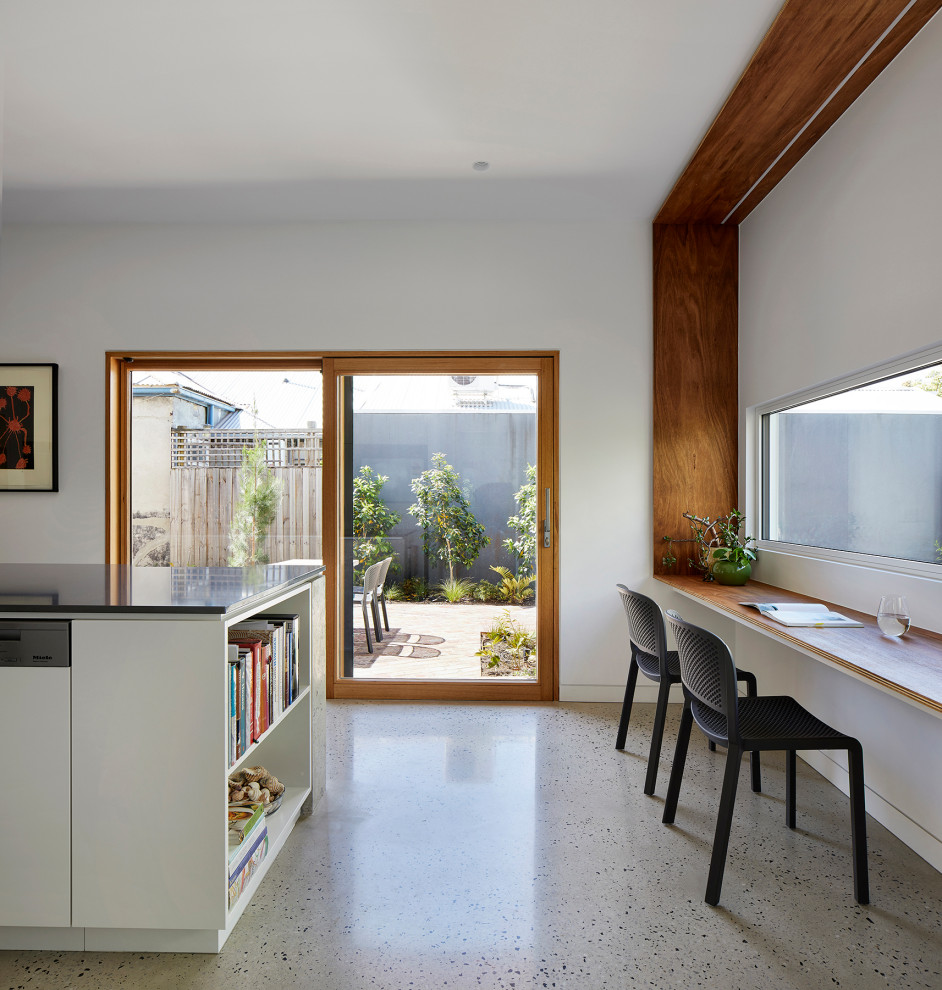 Inspiration for a mid-sized contemporary galley open plan kitchen in Melbourne with a double-bowl sink, white cabinets, quartz benchtops, cement tile splashback, stainless steel appliances, concrete floors, with island, grey floor and grey benchtop.