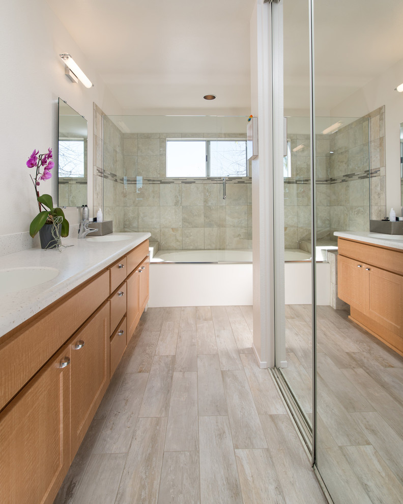 Mid-sized traditional master bathroom in San Diego with a drop-in sink, recessed-panel cabinets, light wood cabinets, engineered quartz benchtops, a drop-in tub, a two-piece toilet, gray tile, porcelain tile, white walls and porcelain floors.