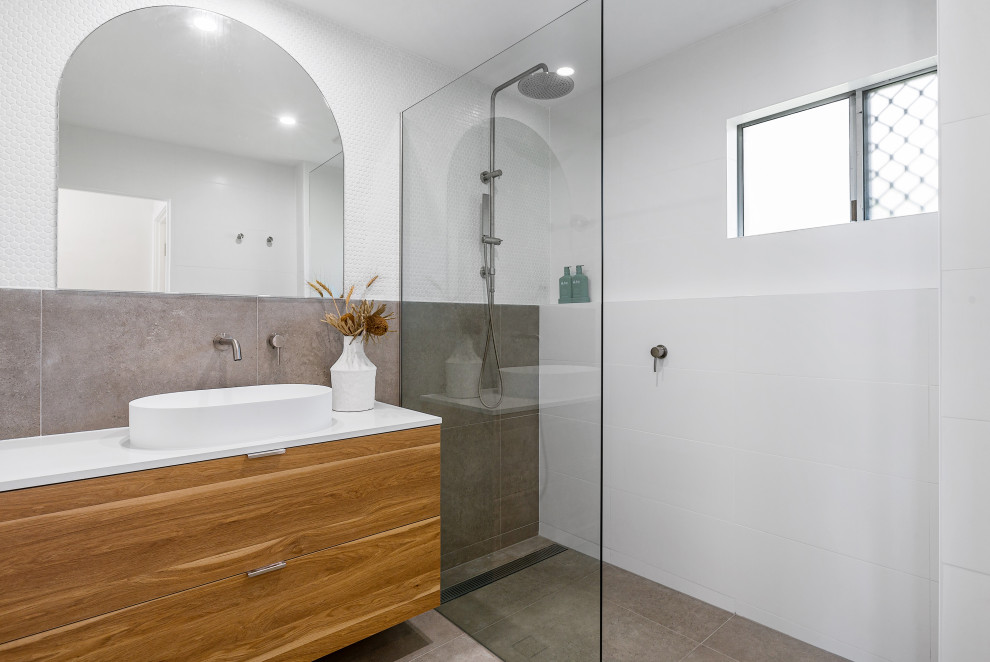 Contemporary bathroom in Gold Coast - Tweed with flat-panel cabinets, medium wood cabinets, an alcove shower, gray tile, white tile, a vessel sink, grey floor, an open shower, white benchtops, a single vanity and a floating vanity.