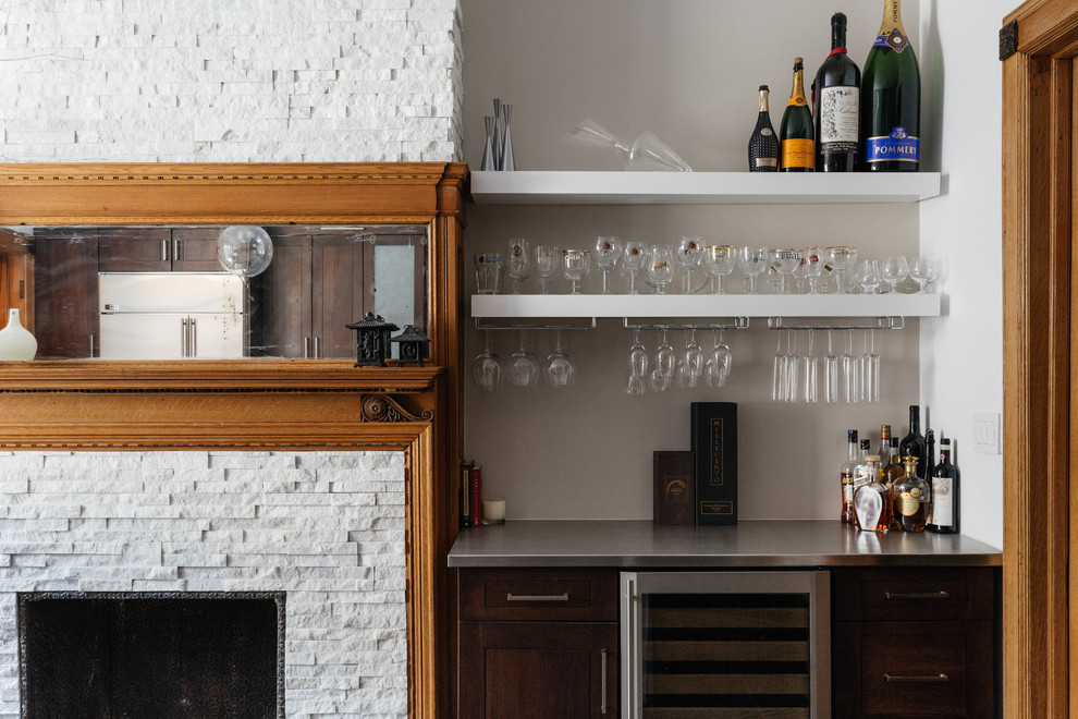 This is an example of a small transitional home bar in New York with no sink, open cabinets and stainless steel benchtops.