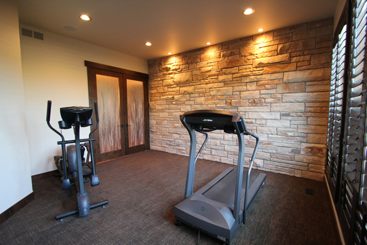 This is an example of a mid-sized contemporary home weight room in Denver with carpet, brown floor and beige walls.