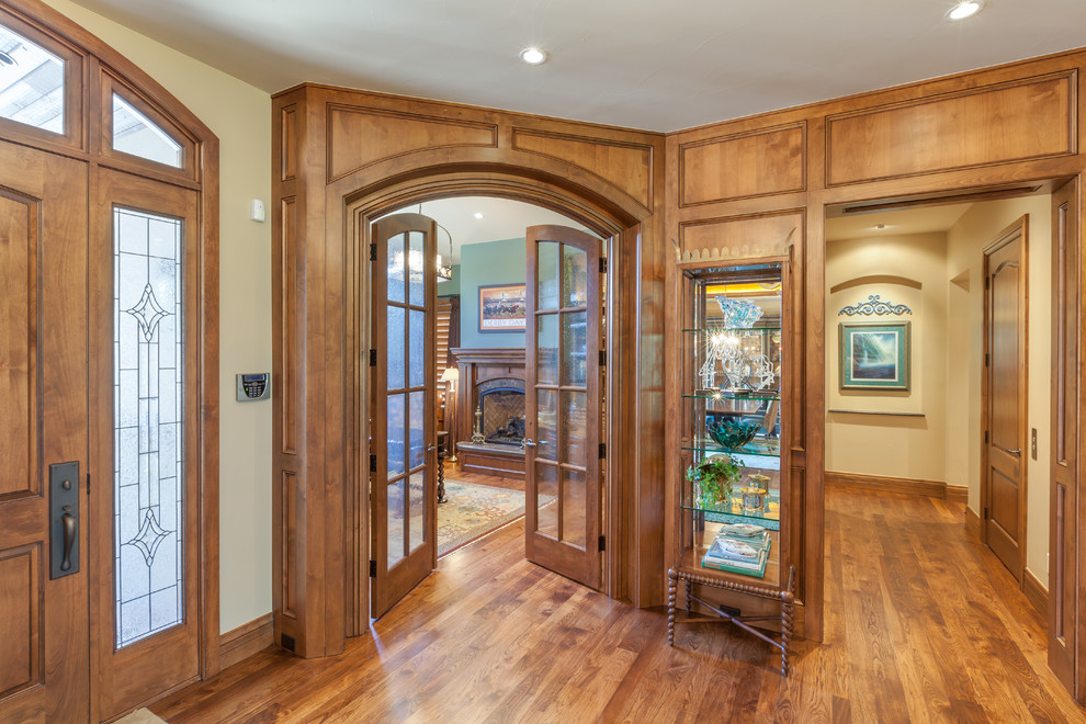 Inspiration for a rustic medium tone wood floor foyer remodel in Denver with beige walls and a medium wood front door