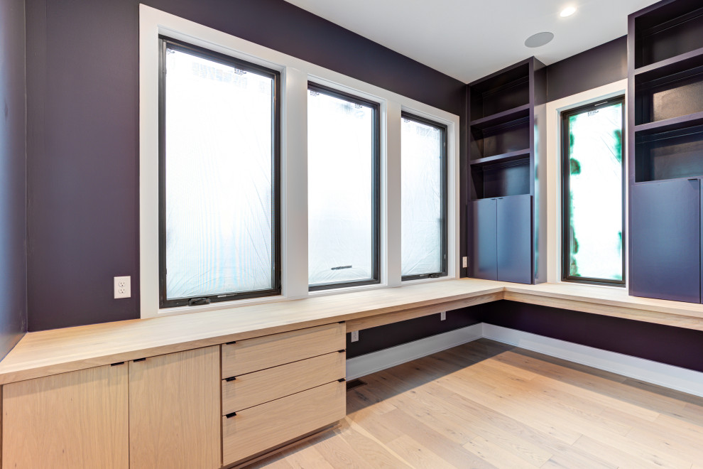 Mittelgroßes Modernes Arbeitszimmer mit blauer Wandfarbe, hellem Holzboden und Einbau-Schreibtisch in Indianapolis