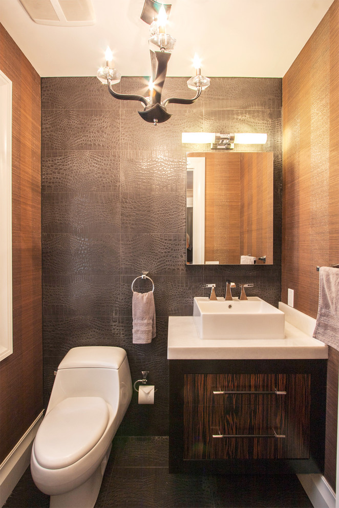 This is an example of a contemporary powder room in New York with a vessel sink, flat-panel cabinets and dark wood cabinets.