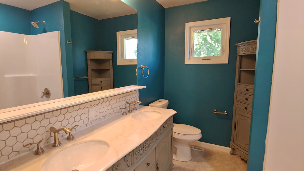 Exemple d'une petite douche en alcôve principale chic avec un placard à porte affleurante, des portes de placard grises, une baignoire en alcôve, un mur bleu, un sol en vinyl, un lavabo intégré, un plan de toilette en surface solide, un sol gris, une cabine de douche avec un rideau, un plan de toilette blanc, meuble double vasque et meuble-lavabo sur pied.