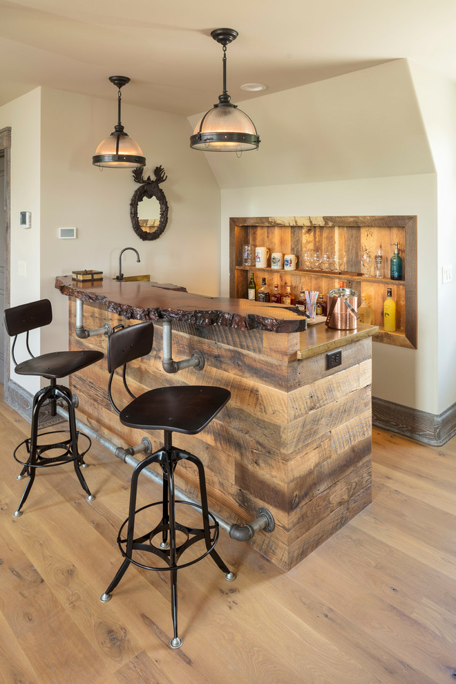 Country galley seated home bar in Minneapolis with open cabinets, wood benchtops, timber splashback, light hardwood floors and brown benchtop.