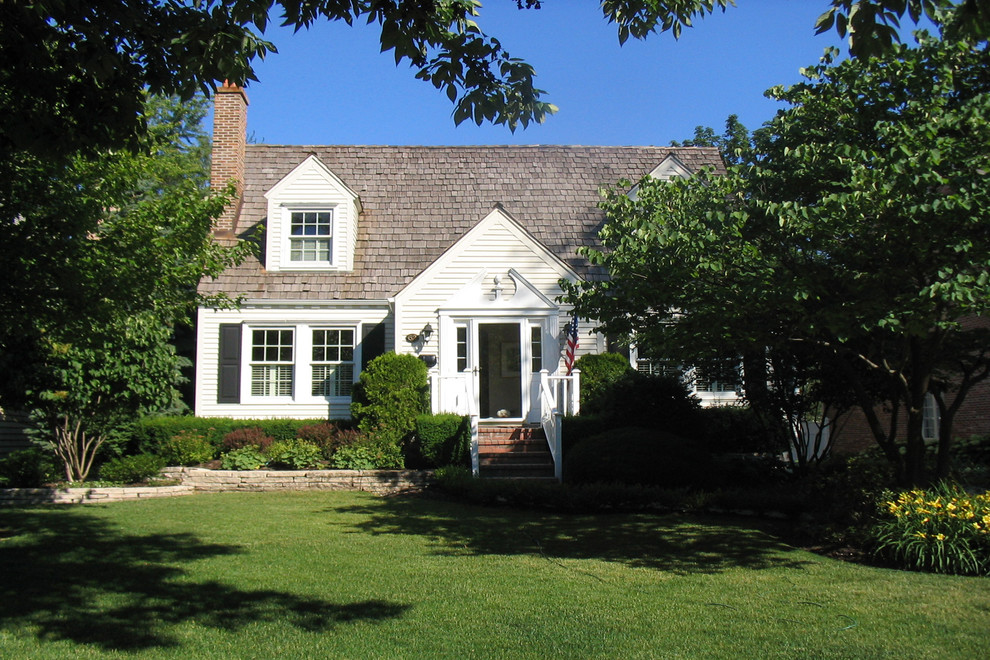 Photo of a traditional one-storey white exterior in Chicago with wood siding and a clipped gable roof.