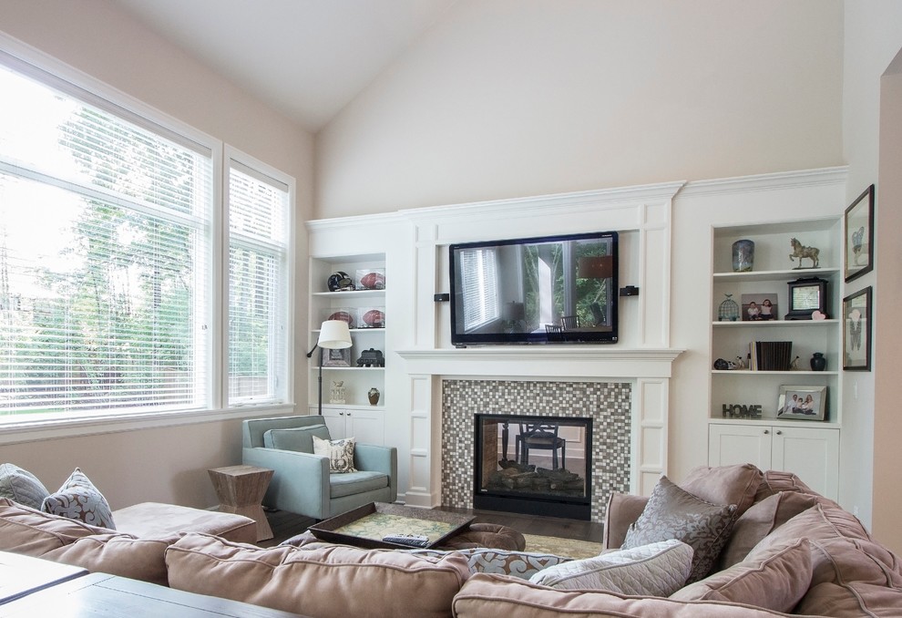 Photo of a transitional living room in Seattle with a two-sided fireplace and a tile fireplace surround.