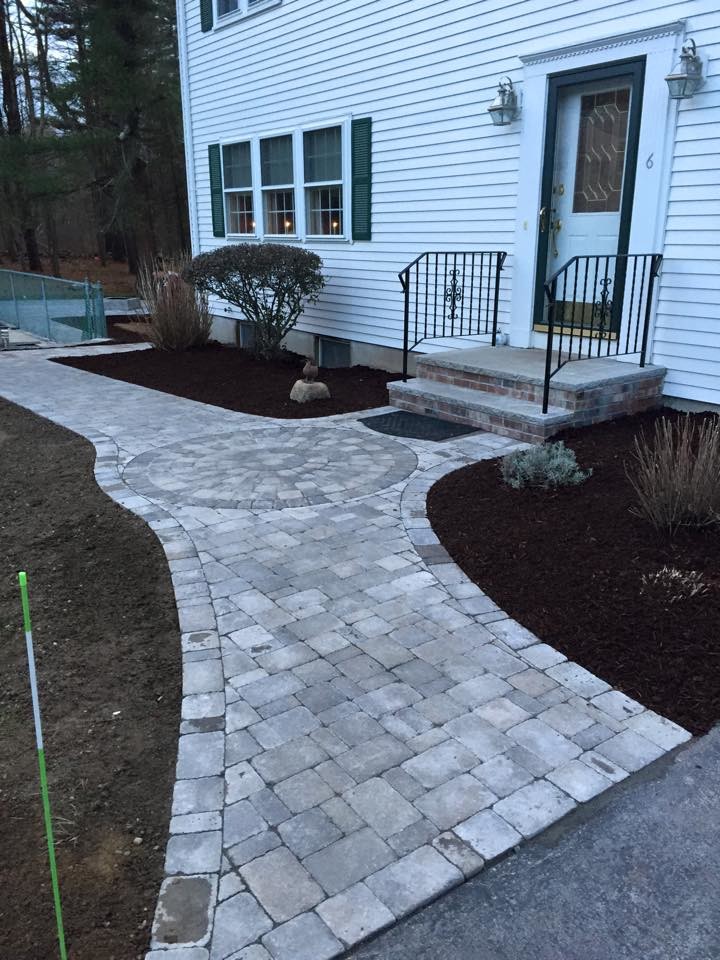 Large front yard garden in Providence with a garden path and natural stone pavers.