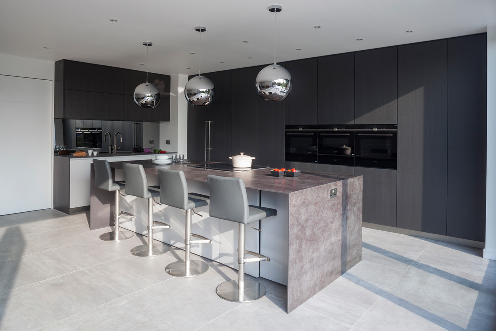 Expansive modern l-shaped open plan kitchen in London with flat-panel cabinets, a peninsula, an integrated sink, brown cabinets, brown splashback, mirror splashback and stainless steel appliances.