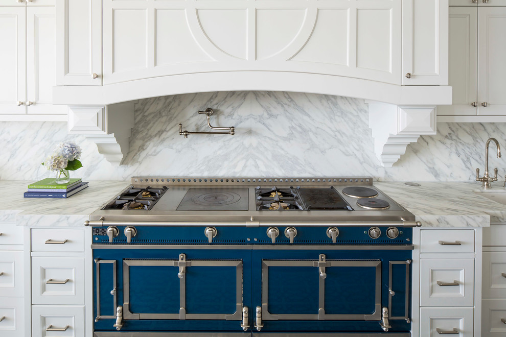 Example of a large transitional l-shaped medium tone wood floor and brown floor open concept kitchen design in Minneapolis with recessed-panel cabinets, white cabinets, marble countertops, white backsplash, marble backsplash, colored appliances, an undermount sink and an island