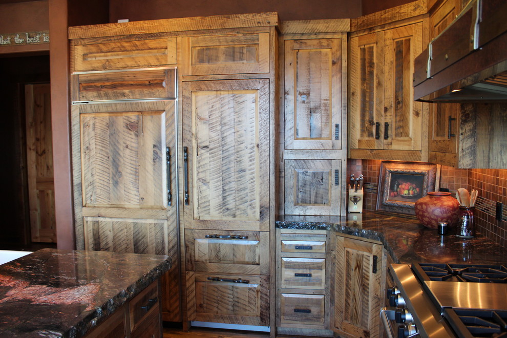 Example of a mid-sized mountain style u-shaped medium tone wood floor eat-in kitchen design with a farmhouse sink, raised-panel cabinets, distressed cabinets, granite countertops, multicolored backsplash, glass tile backsplash, paneled appliances and an island