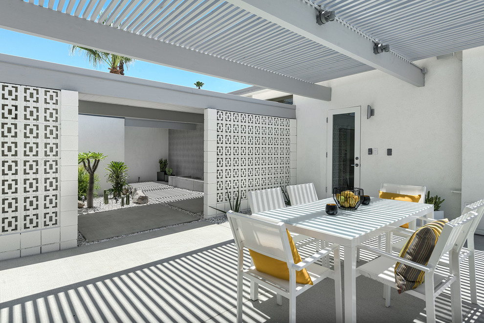 Photo of a midcentury courtyard patio in Los Angeles with a pergola.
