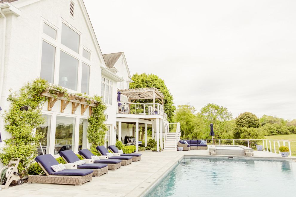 Foto de casa de la piscina y piscina infinita contemporánea grande rectangular en patio trasero con adoquines de piedra natural