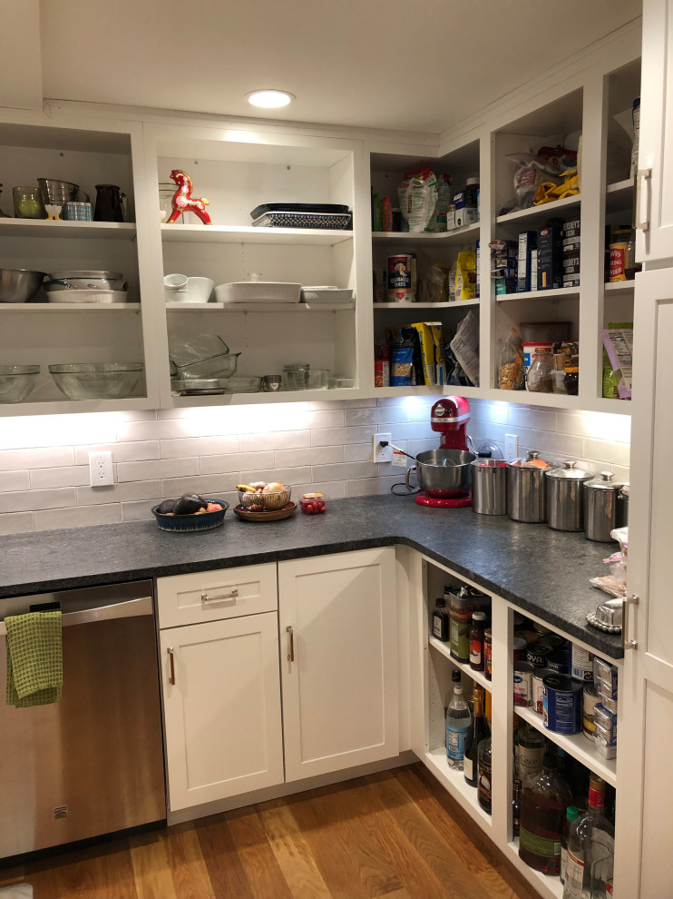 Inspiration for a mid-sized transitional u-shaped medium tone wood floor and brown floor kitchen pantry remodel in Boston with an undermount sink, shaker cabinets, white cabinets, granite countertops, white backsplash, stainless steel appliances, no island, black countertops and subway tile backsplash