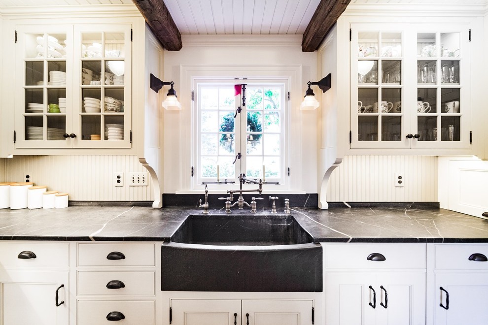 Eat-in kitchen - large transitional u-shaped medium tone wood floor and brown floor eat-in kitchen idea with a farmhouse sink, recessed-panel cabinets, white cabinets, soapstone countertops, green backsplash, paneled appliances, an island and gray countertops