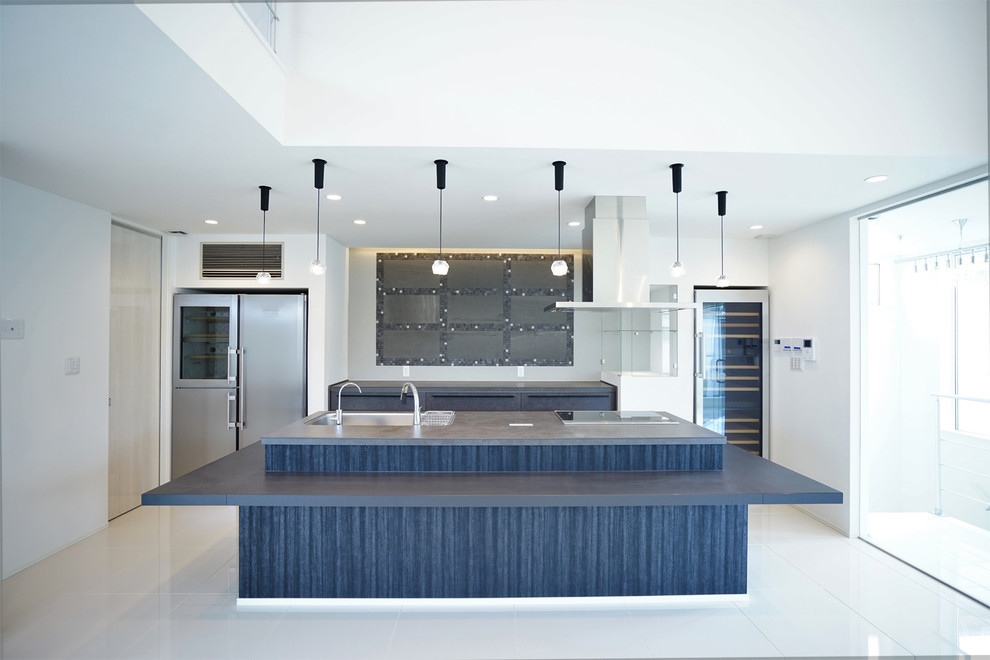 This is an example of an expansive modern single-wall open plan kitchen in Other with a single-bowl sink, solid surface benchtops, grey splashback, marble floors, with island, white floor and grey benchtop.