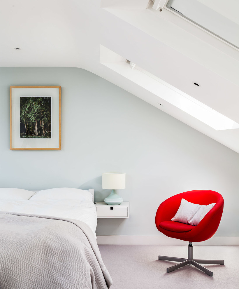 This is an example of a mid-sized contemporary guest bedroom in London with carpet.