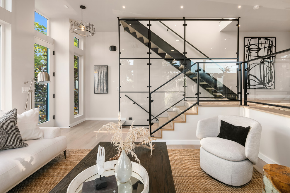 This is an example of a modern wood straight staircase in Seattle with open risers and glass railing.