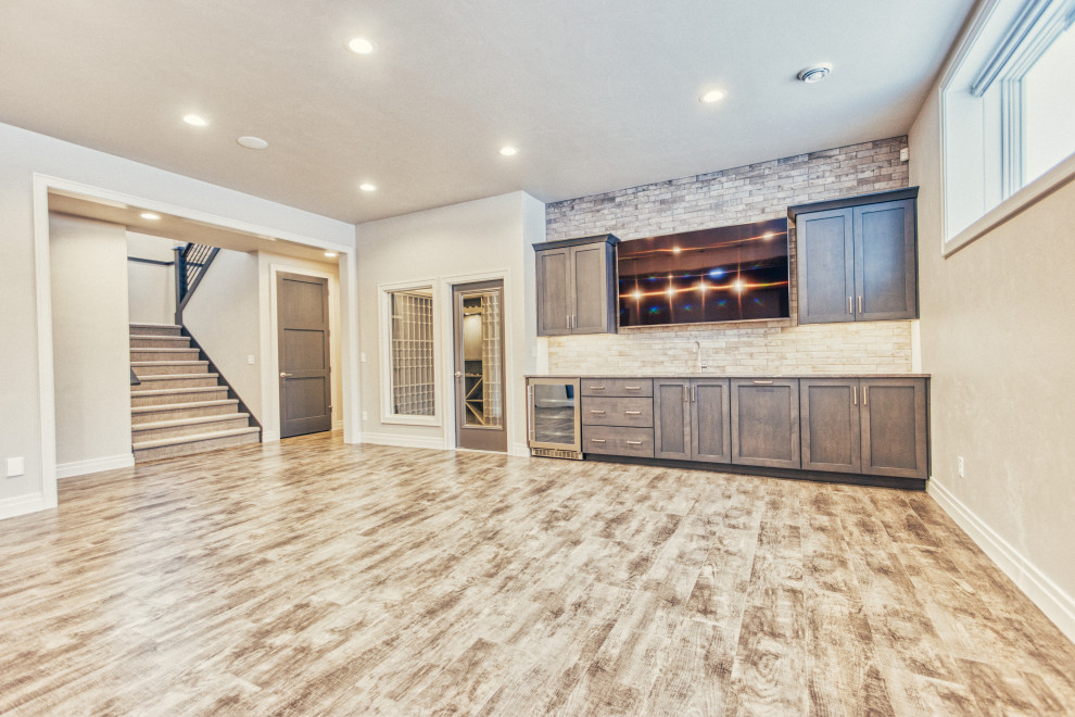 Example of a large transitional look-out vinyl floor and multicolored floor basement design with gray walls