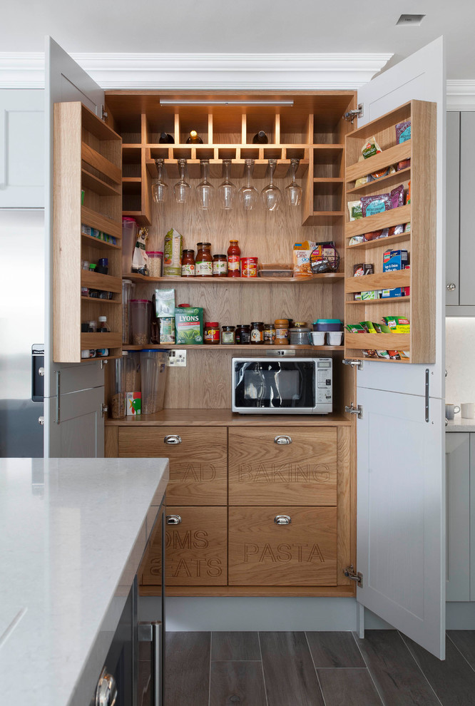 This is an example of a large traditional kitchen pantry in Other with shaker cabinets, grey cabinets, quartzite benchtops, grey splashback, stone slab splashback, stainless steel appliances, porcelain floors, with island and brown floor.