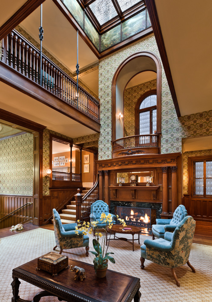 This is an example of a traditional open concept family room in Philadelphia with beige walls and a standard fireplace.
