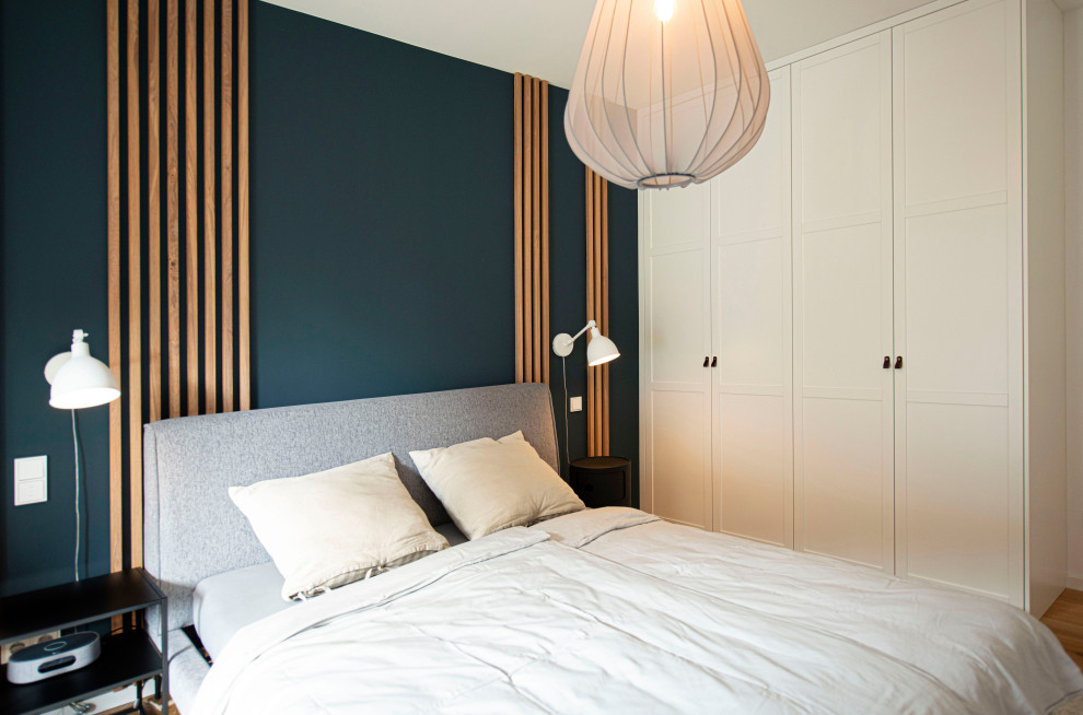 Mittelgroßes Modernes Schlafzimmer mit blauer Wandfarbe, gebeiztem Holzboden und braunem Boden in Sonstige