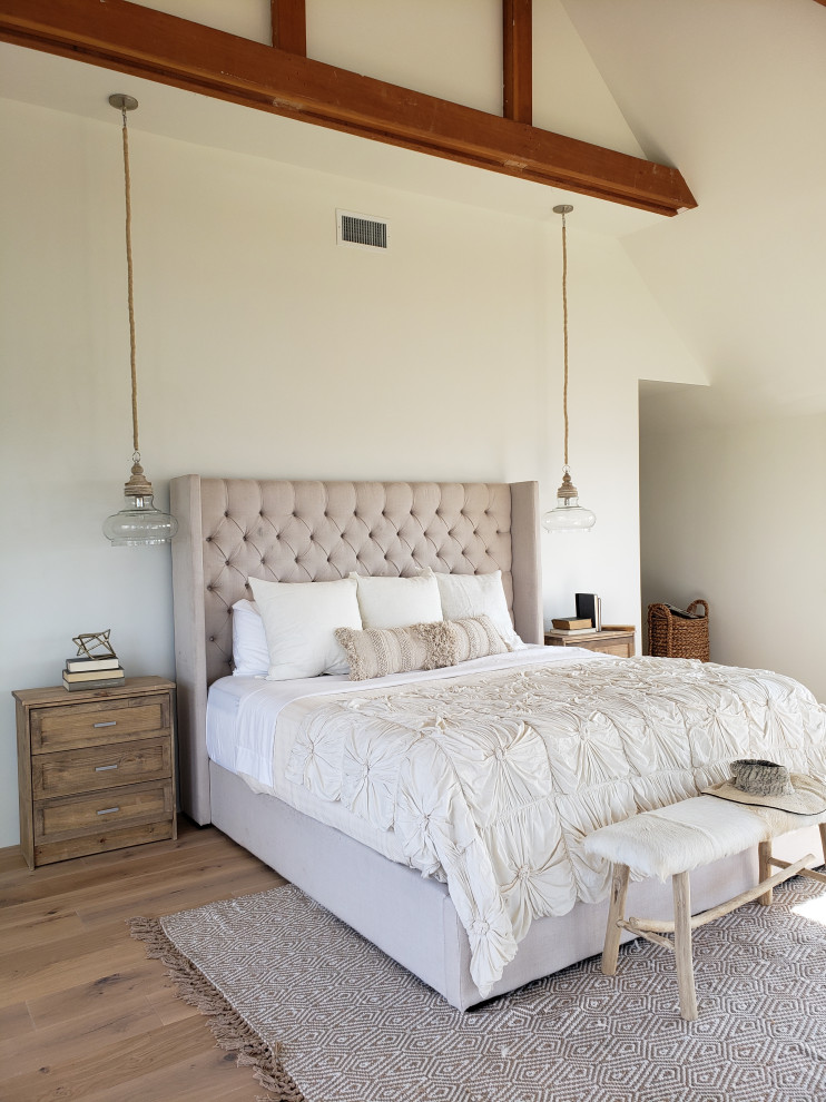 ポートランドにある広いカントリー風のおしゃれな主寝室 (白い壁、無垢フローリング、暖炉なし、ベージュの床、表し梁)