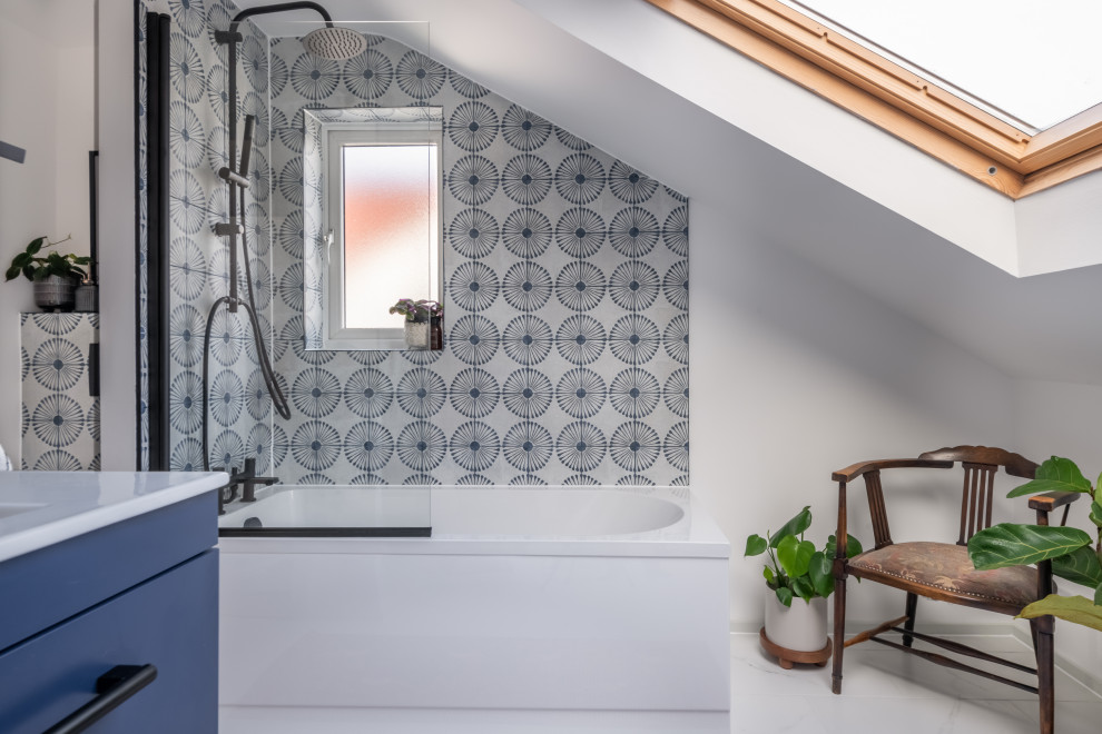 Inspiration for a contemporary bathroom in Other with flat-panel cabinets, blue cabinets, a corner bath, blue tiles, white walls, white floors, an open shower, white worktops, a single sink and a vaulted ceiling.