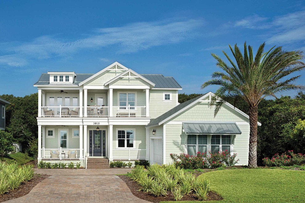 Inspiration for a beach style two-storey green exterior in Jacksonville with mixed siding and a gable roof.