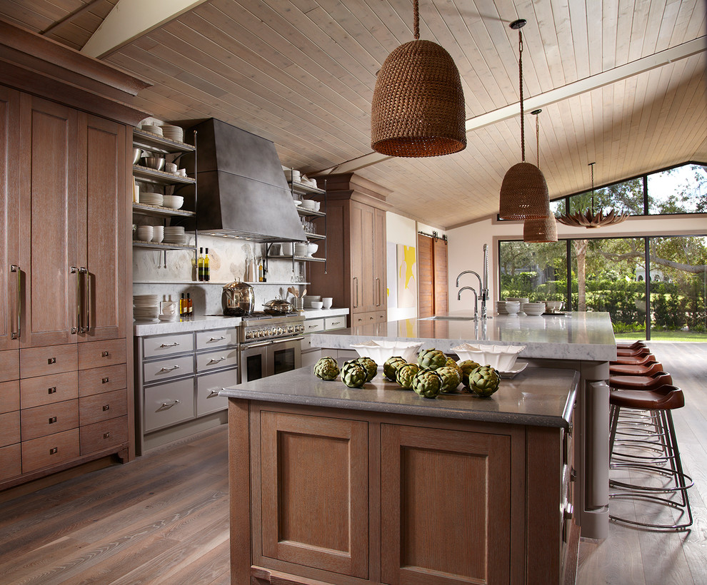 Inspiration for a country galley open plan kitchen in Miami with an undermount sink, flat-panel cabinets, grey cabinets, stainless steel appliances, light hardwood floors and with island.