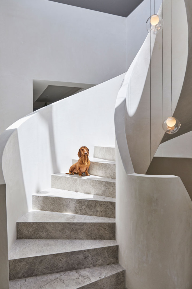 Photo of an expansive modern limestone spiral staircase in Melbourne with limestone risers.