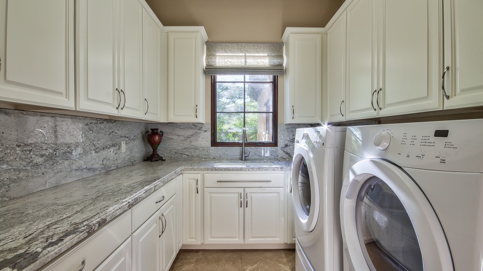 Inspiration for a mediterranean galley utility room in Phoenix with an undermount sink, raised-panel cabinets, white cabinets, soapstone benchtops, beige walls, ceramic floors and a side-by-side washer and dryer.