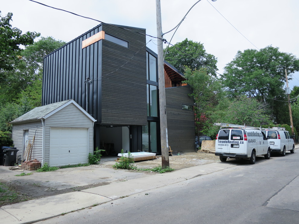This is an example of a contemporary black exterior in Toronto with wood siding.