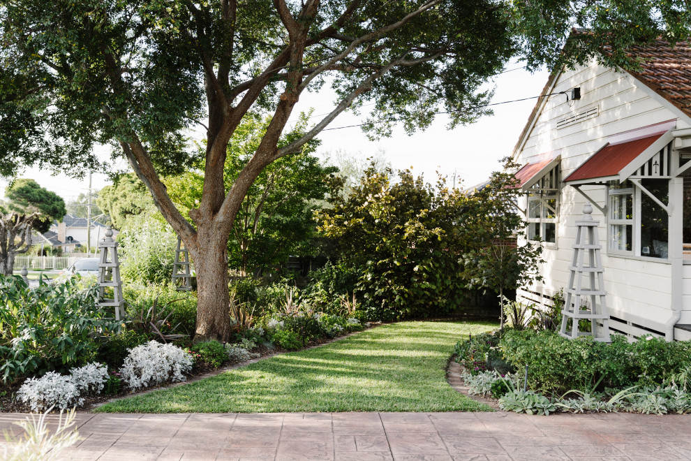Пример оригинального дизайна: маленький весенний засухоустойчивый сад на переднем дворе в стиле кантри с садовой дорожкой или калиткой, полуденной тенью, мощением клинкерной брусчаткой и с деревянным забором для на участке и в саду