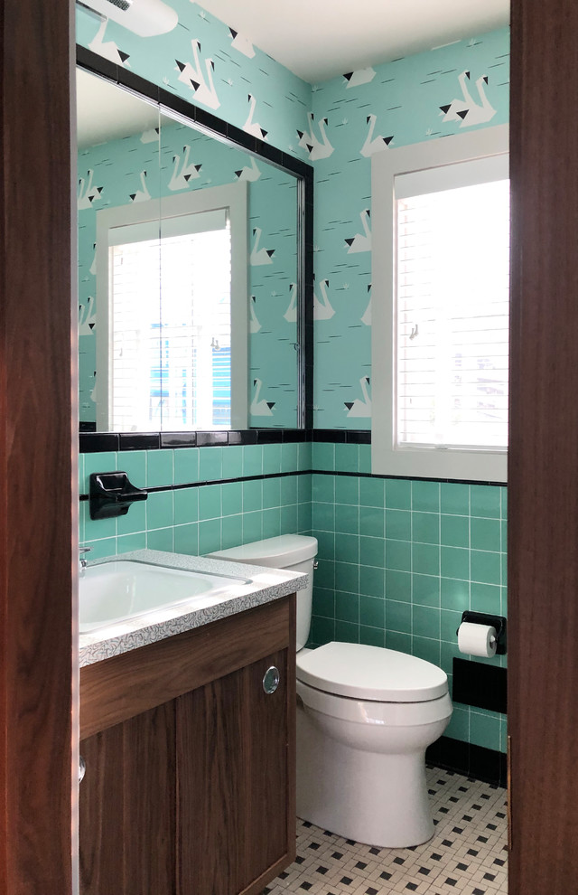 Photo of a small midcentury bathroom in New York with flat-panel cabinets, dark wood cabinets, an alcove shower, a two-piece toilet, blue tile, ceramic tile, ceramic floors, a drop-in sink, laminate benchtops, white floor, a hinged shower door and yellow benchtops.