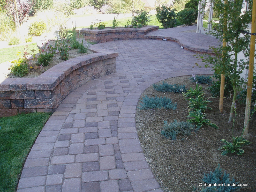 Inspiration for a mid-sized traditional backyard garden in Other with a garden path and brick pavers.