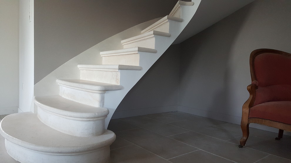 Стильный дизайн: п-образная лестница с ступенями из известняка и подступенками из известняка - последний тренд