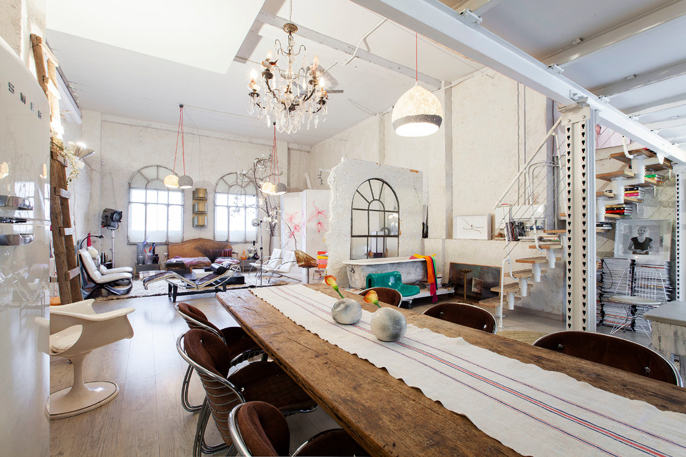 Photo of an expansive eclectic open plan dining in Madrid with white walls, medium hardwood floors and no fireplace.