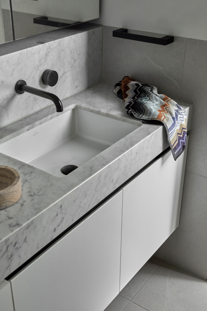 Small contemporary bathroom in Melbourne with white tile, porcelain tile, white walls, porcelain floors, marble benchtops, grey floor, white benchtops, a single vanity and a built-in vanity.