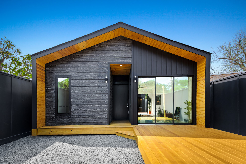 Kleines, Einstöckiges Modernes Einfamilienhaus mit Faserzement-Fassade, schwarzer Fassadenfarbe, Satteldach, Schindeldach, schwarzem Dach und Wandpaneelen in Houston