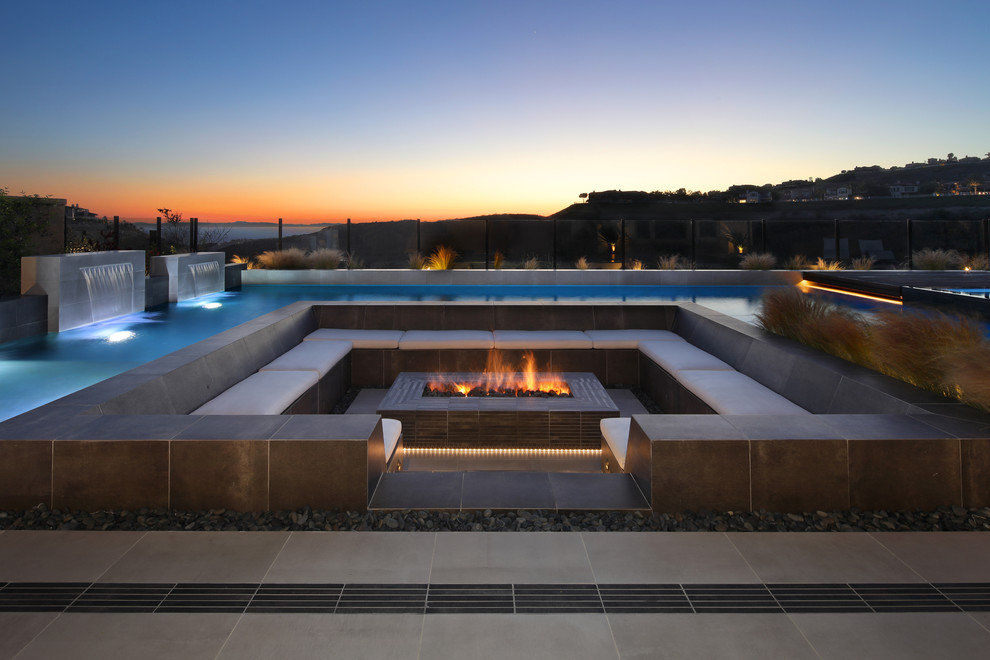 Photo of a contemporary backyard patio in Orange County with a water feature, tile and no cover.